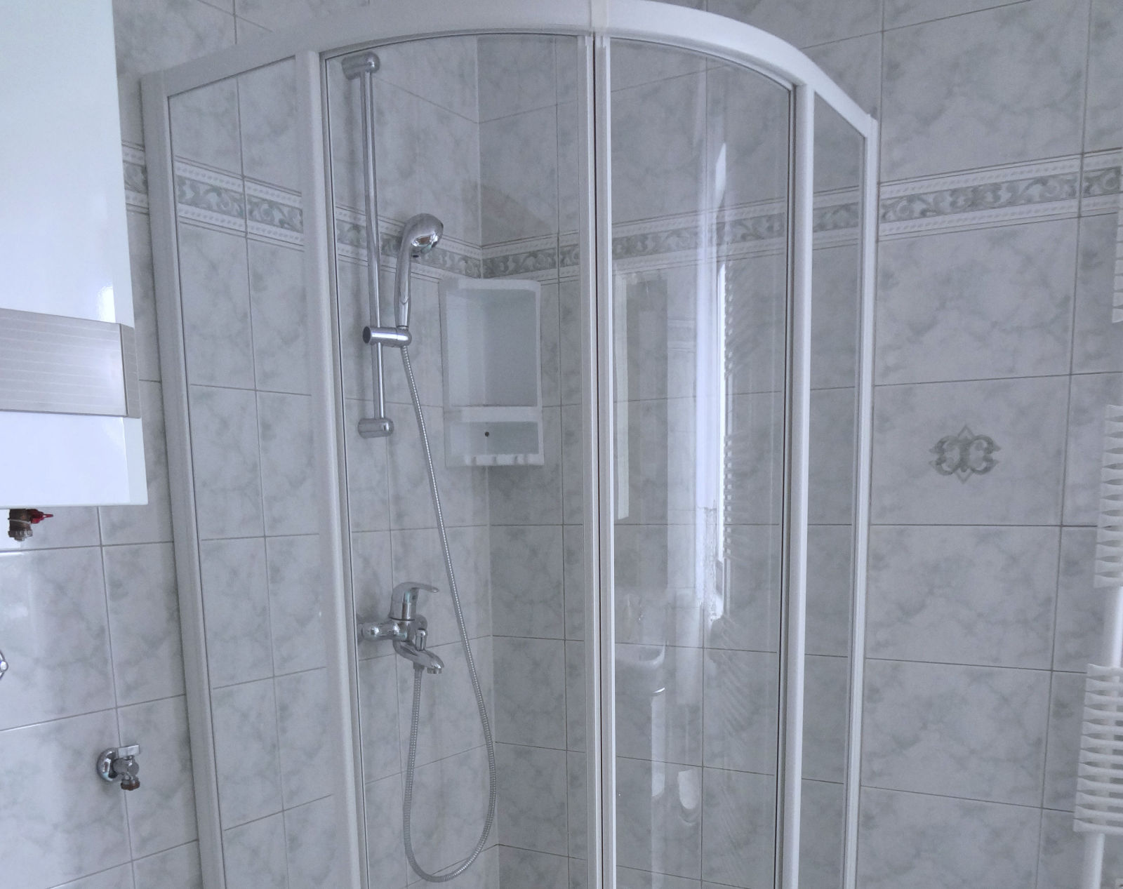 A glass shower stall in the bathroom of the Fine Stay Bled apartment in Lake Bled, Slovenia
