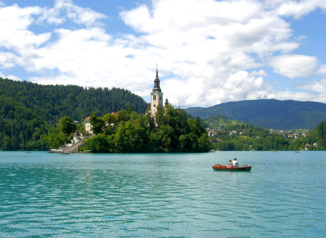 A couple in a boat at Lake Bled rowing towards Bled Island