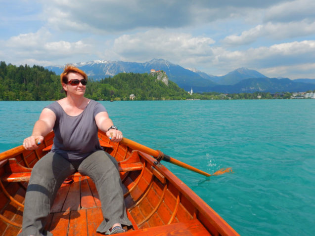 A female rowing in a wooden rowboat at Lake Bled in Slovenia