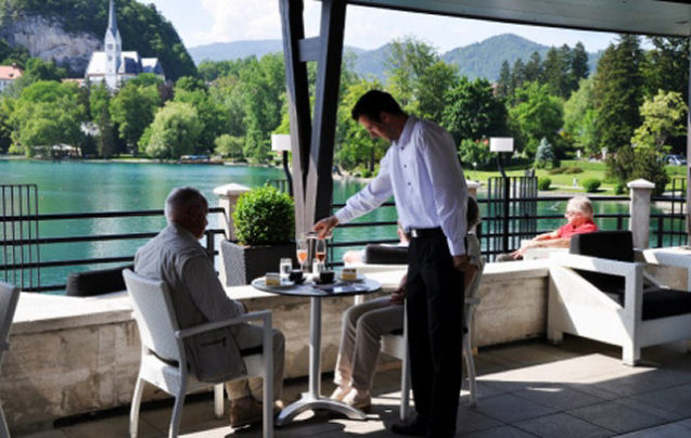 A waiter serving a customer on the terrace at Restaurant Cafe Park in Bled