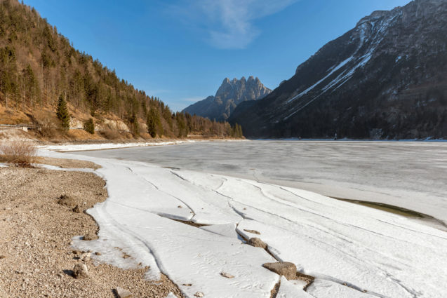 The frozen Lake Predil in winter with the Cinque Punte mountain in the background