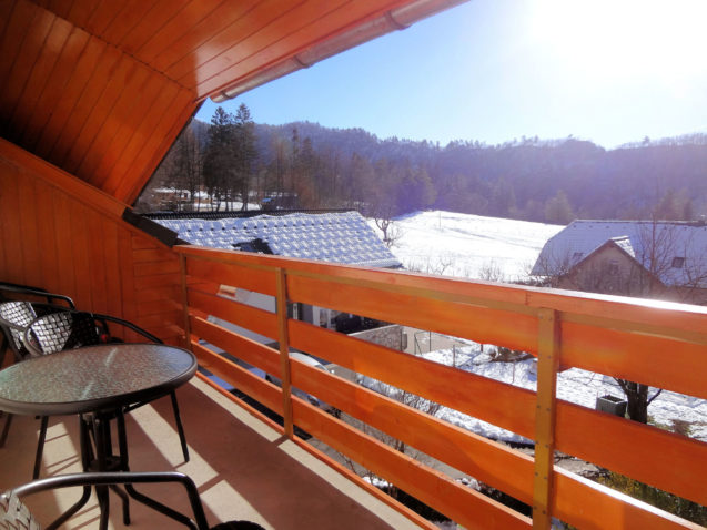 A wintry view of the snow covered pasture from the balcony of Apartments Fine Stay