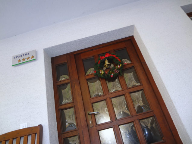 A Christmas wreath hanging on the front door of Fine Stay Apartments