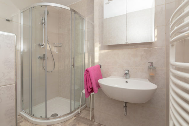 A glass shower stall and a washing machine in the bathroom of the Modern Apartment With Balcony and Terrace, Apartments Fine Stay