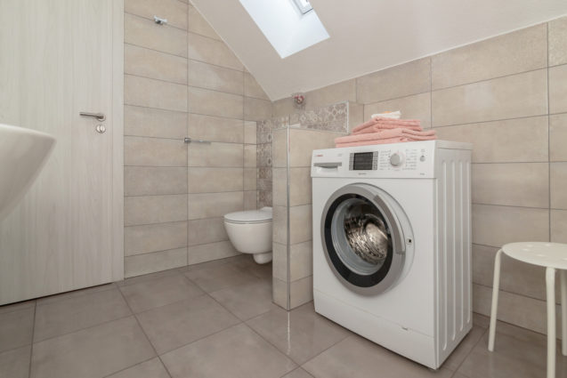 A washing machine and a toilet in the bathroom of Modern Apartment With Balcony, Apartments Fine Stay