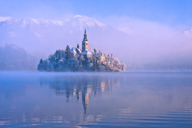 Bled Island covered with snow in the middle of Lake Bled