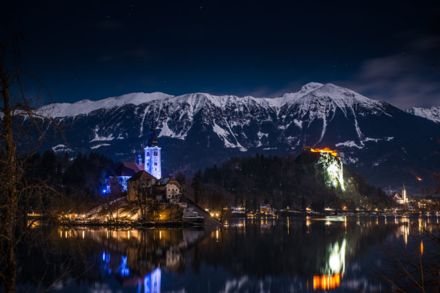 Lake Bled with its island with a church and a medieval castle at night in winter