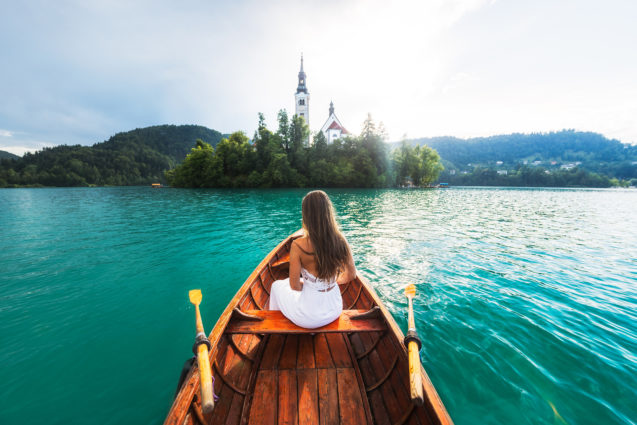 A woman in a boat at Lake Bled in Slovenia with Bled Island in the background