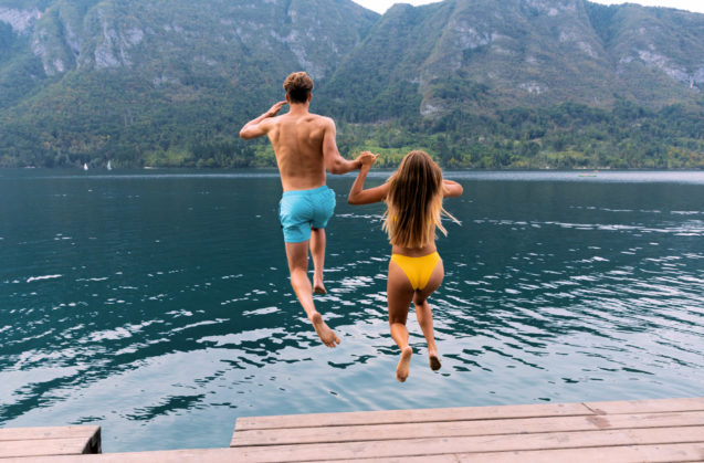 A young couple swimming in Lake Bohinj in summer 
