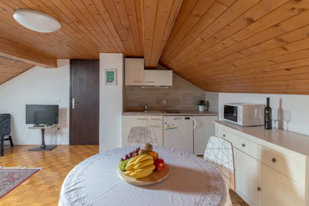 The kitchenette and a wooden dining table with three chairs in the loft Apartment at Apartments Fine Stay Bled