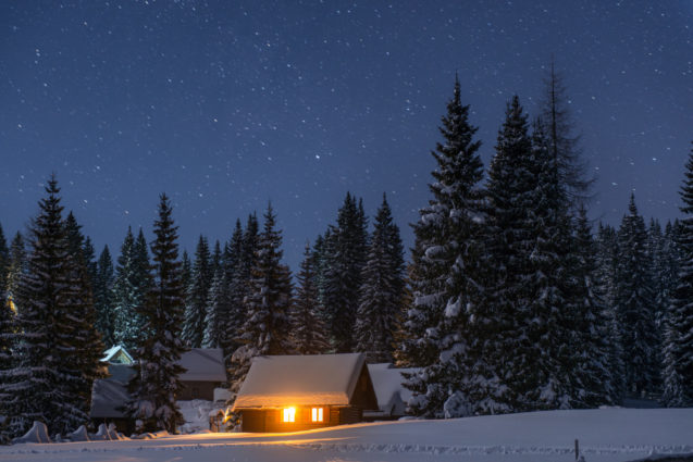 A cottage covered with snow at Pokljuka Plateau at night