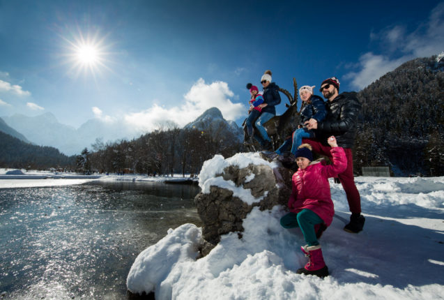 A family enjoying winter activities at Lake Jasna in Kranjska Gora in winter
