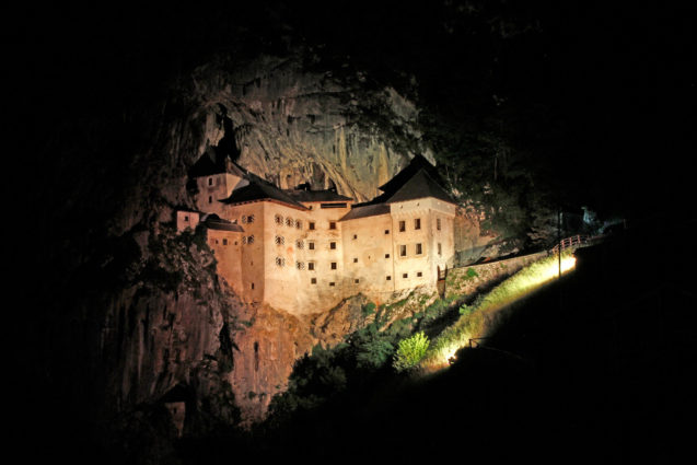 Predjama Castle built into the mouth of a cave in Postojna at night