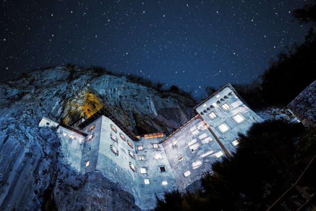 Predjama Castle built into the mouth of a cave in Postojna on a starry night