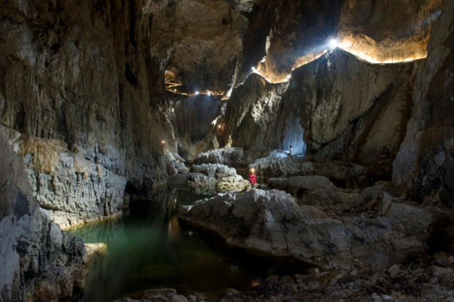Lighted pathways marking the path alongside Reka River in Skocjan Caves
