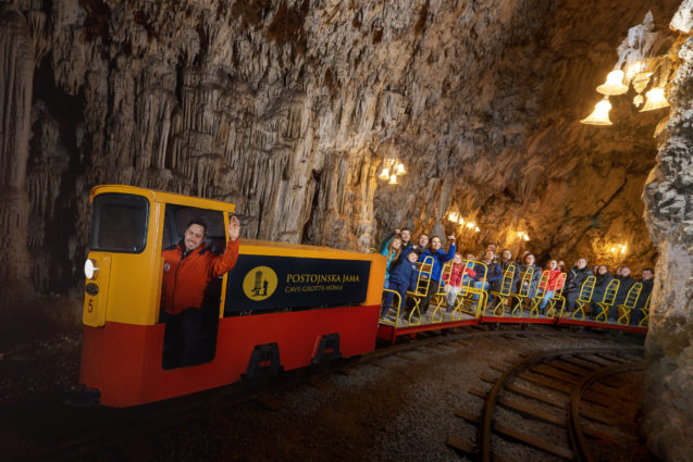 A tourist train with tourists inside Postojna Cave in Slovenia