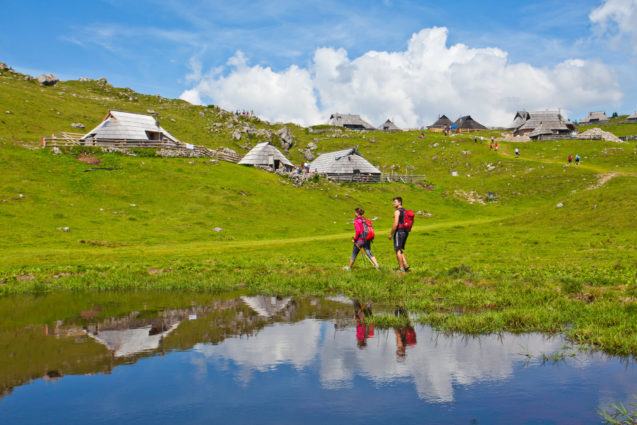 A pair of hikers hiking at Velika Planina in Slovenia in summer