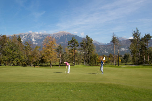 A female golfer at Royal Bled Golf course with Mount Stol in the background