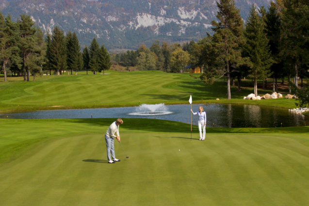 Golfer putting on the green at Royal Bled Golf course in Slovenia