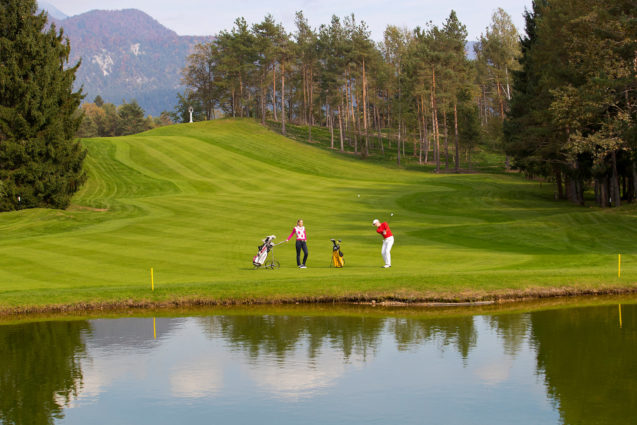 Golfer hitting golf shot at Royal Bled Golf course in Slovenia