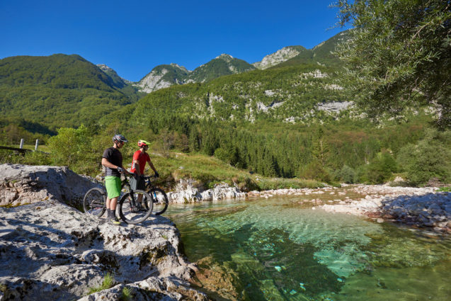 Two cyclists next to the Soca River in Slovenia
