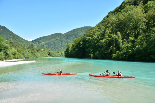 Water-sports enthusiasts kayaking on the Soca River in Slovenia