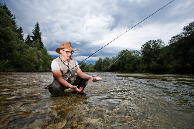 A fisherman flyfishing in the middle of River Sava in Slovenia