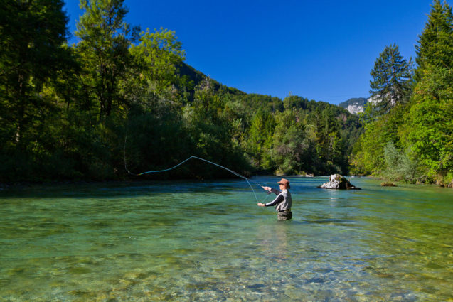 A fisherman flyfishing in Sava River in Slovenia