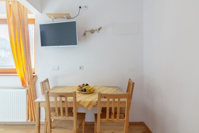 Dining table and television in Cosy Apartment With Terrace at Apartments Valant Bled in Slovenia