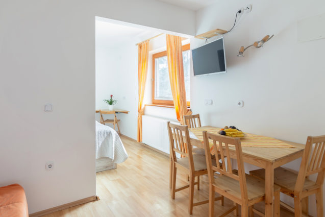 Dining table and TV in Cosy Apartment With Terrace at Apartments Valant Bled in Slovenia