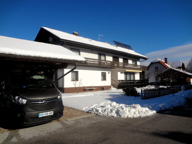 Covered parking and exterior of accommodation Apartments Fine Stay Bled in Slovenia covered in snow in winter